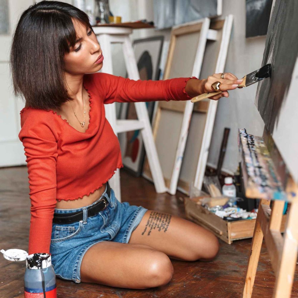 portrait-of-young-woman-using-painting-tools-while-KZHY4GP.jpg